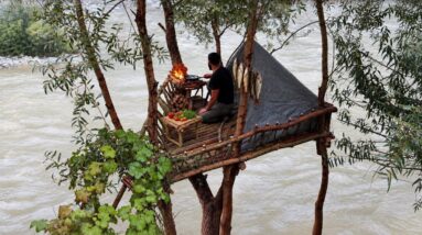 Elevated river treehouse bushcraft shelter built from natural wood above a rushing river