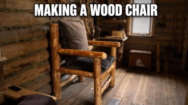 Builder assembling a custom wooden log chair inside an off-grid log cabin using hand tools